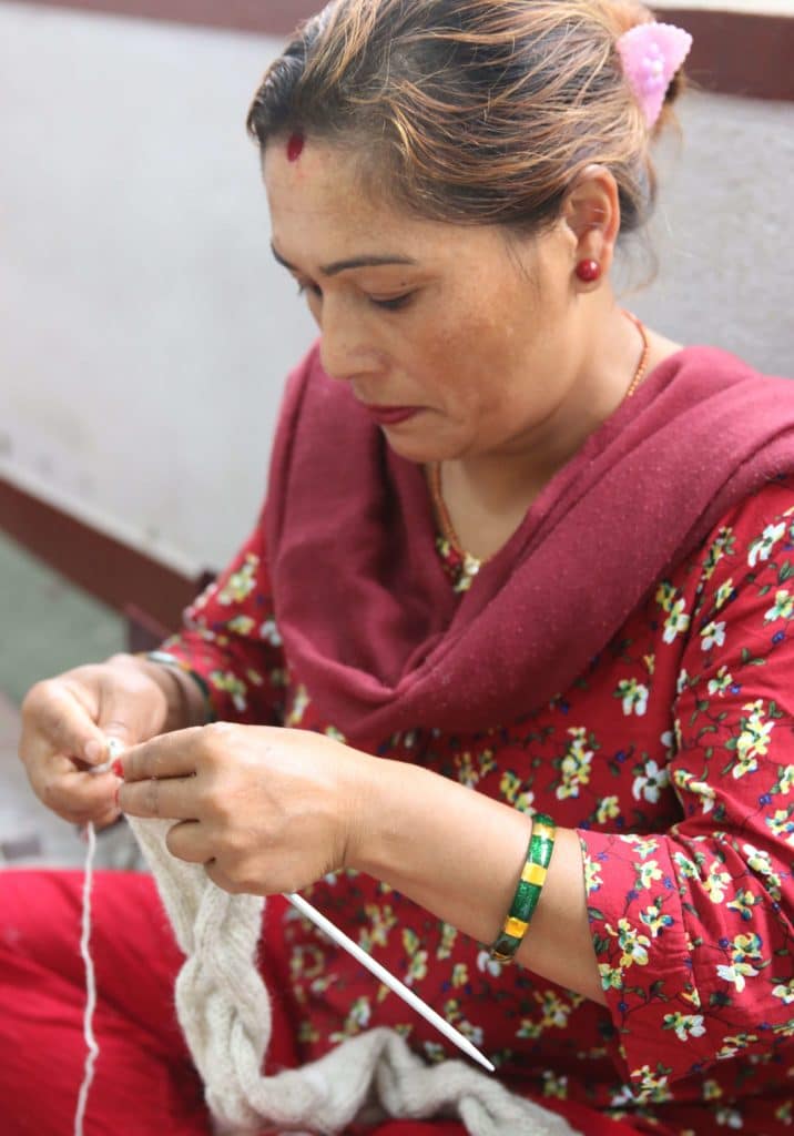 Donne che lavorano a maglia un maglione fatto a mano con lana presso Rochak Handknit Craft