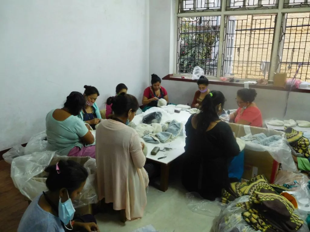 Vrouwen bij Rochak Handknit werken samen.